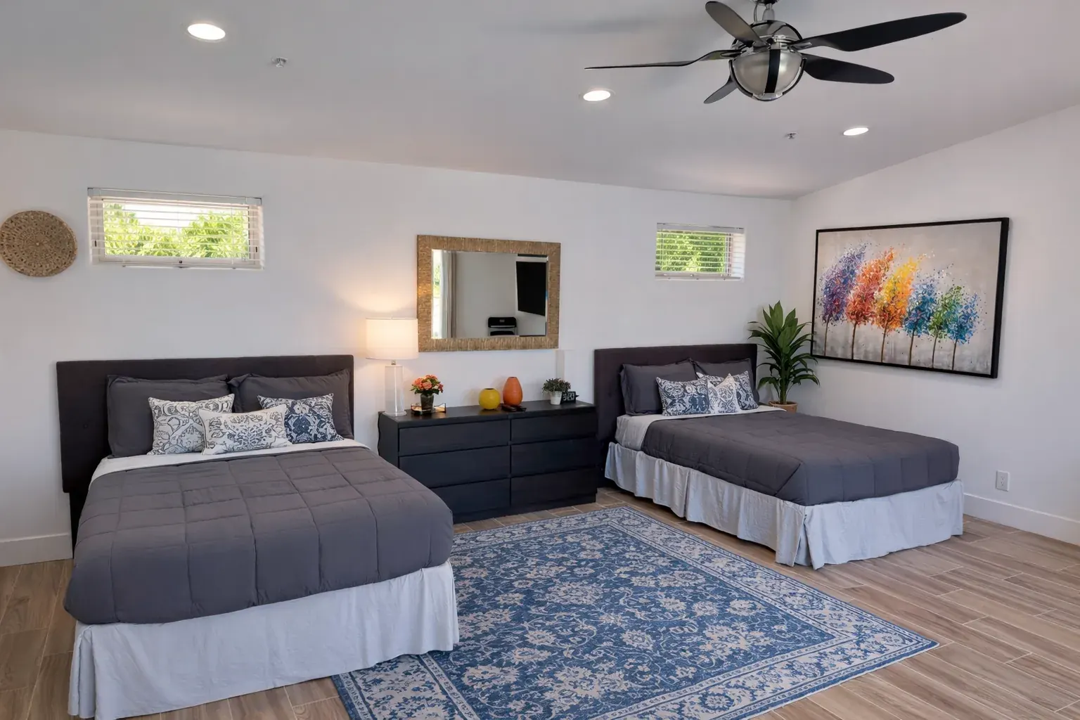 Shared bedroom with two beds, soft natural daylight, and a rug at the Palm Springs residential treatment home