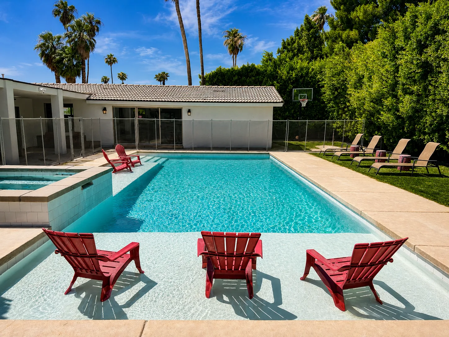 Private pool framed by palms, red Adirondack chairs, and desert mountain views at the Mental Wellness KS facility in Palm Springs